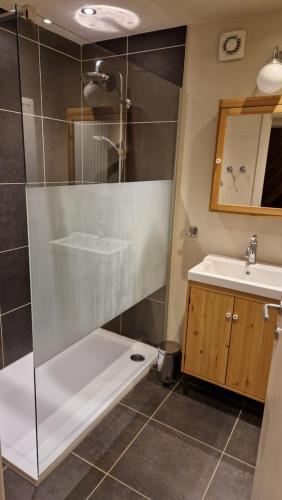 een badkamer met een douche, een bad en een wastafel bij Chalet Coo in Stavelot