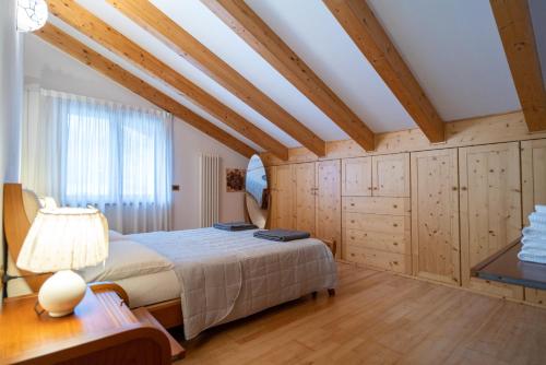 een slaapkamer met een groot bed en houten plafonds bij La casa di Terlago 2 in Trento