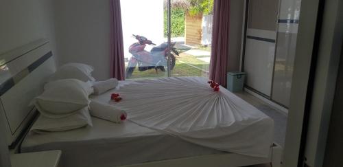 a white bed with an umbrella in a room at Clove Beach in Addu Atoll