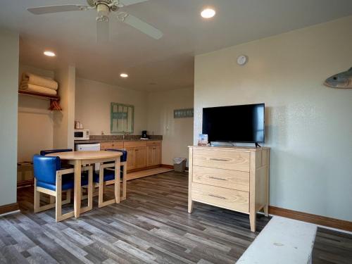 a living room with a table and a flat screen tv at Pony Island Inn in Ocracoke