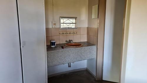 a bathroom with a sink and a window at Kiaat Bungalows in Hazyview