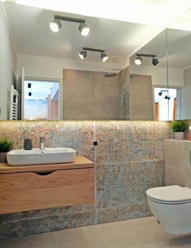 a bathroom with a sink and a toilet at Apartamenty Na Skarpie in Ełk