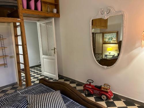 - une chambre avec un miroir et une voiture à jouets à l'étage dans l'établissement Home Rome Lepanto, à Rome