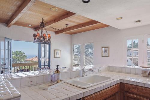 a large kitchen with a large sink and windows at 3263 Villa by the Sea townhouse in Pacific Grove