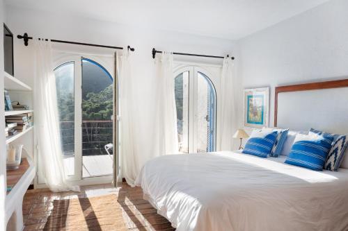 una camera bianca con un grande letto con cuscini blu di Flateli Sa Tuna 3 a Begur