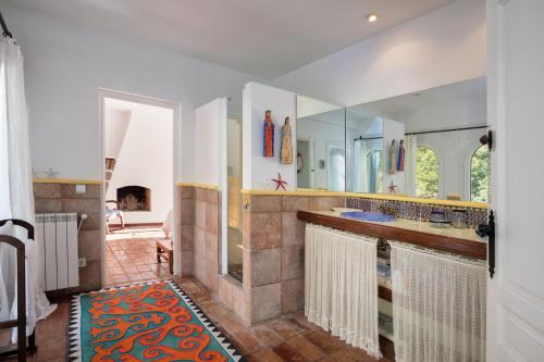 un bagno con un lavandino e un grande specchio di Flateli Sa Tuna 3 a Begur