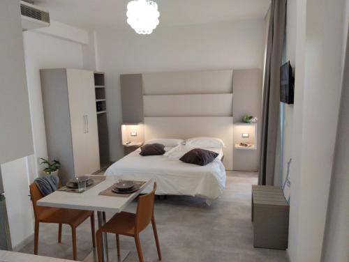 um quarto com uma cama e uma mesa com cadeiras em Hotel Abel & Residence em Cesenatico