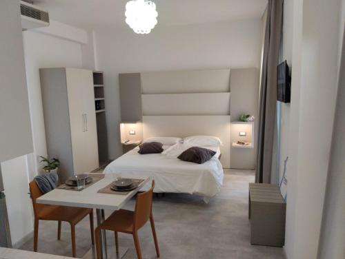 a bedroom with a bed and a table with chairs at Hotel Abel & Residence in Cesenatico