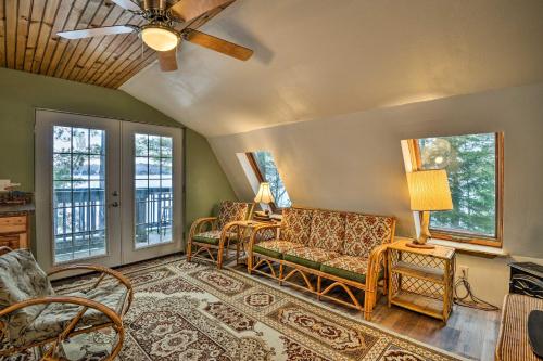 een woonkamer met een bank, stoelen en ramen bij Lakefront Harrisville Cabin with Dock and Decks! in Harrisville