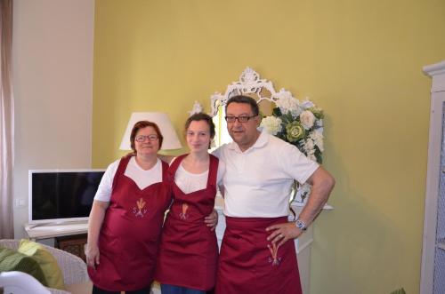 a man and two women wearing aprons posing for a picture at B&B San Valerio in Occimiano