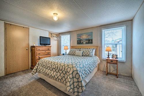 a bedroom with a bed and a dresser and a television at Peaceful Supply House about 2 Mi to Holden Beach! in Supply