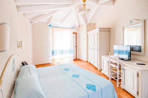 a large bedroom with a bed and a tv at Marina Torre Navarrese Resort in Santa Maria Navarrese