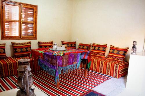 ein Wohnzimmer mit einem Tisch und 2 Sofas in der Unterkunft Pergolas Tamakouchte in Ouarzazate