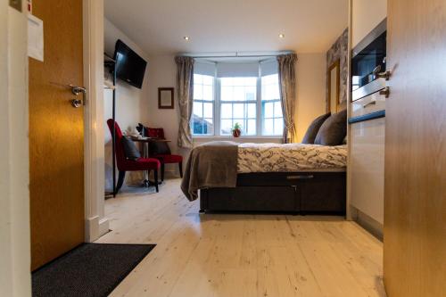 a bedroom with a bed with a window and a desk at Domus House Studio Apartments in Chester city centre with Free Parking by Rework Accommodation in Chester