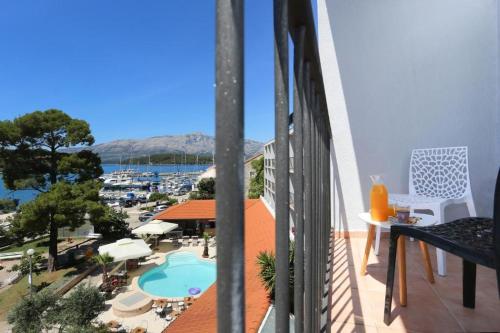 a balcony with a view of a pool and a marina at Hotel Lumbarda in Lumbarda