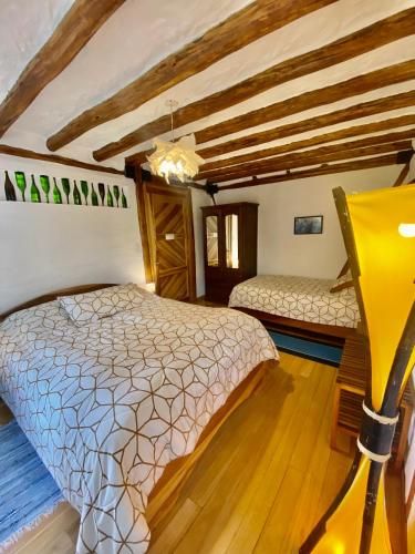 a bedroom with two beds in a room with wooden ceilings at Casa Magnolia in Cumbayá