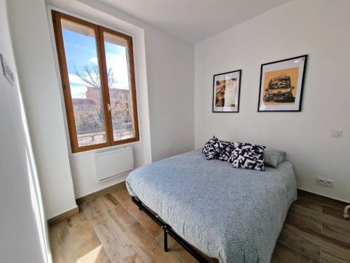 een slaapkamer met een bed en een raam bij Gregbnb-com - T2 37m2 -1- Est - in Toulon