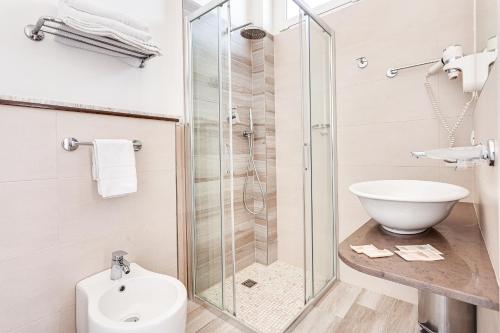 a bathroom with a shower and a toilet and a sink at Hotel Fantini in Gatteo a Mare