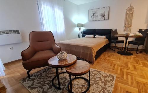 a living room with a bed and a couch and a table at Apartman TIM LUX 1 in Vrnjačka Banja