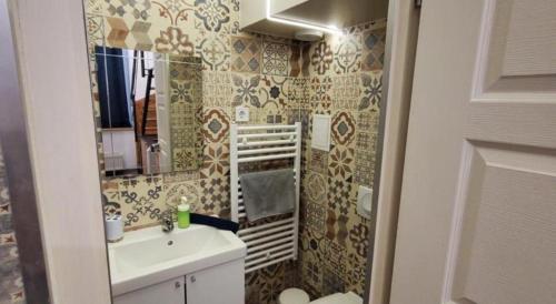 a small bathroom with a sink and a mirror at Klauzal19 Rooms in Budapest