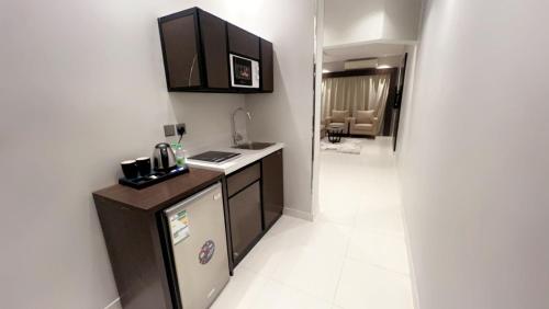 شقق البندقية للوحدات الفندقية ALBUNDUQI HOTEl في الرياض: مطبخ صغير مع حوض ومكتب