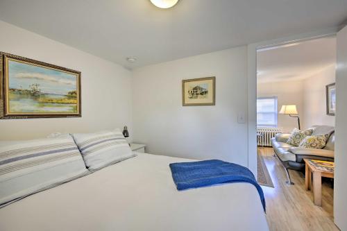 um quarto com uma cama branca e um sofá em Quaint DT Greenport Apt - 2 Mi to Shelter Island! em Greenport
