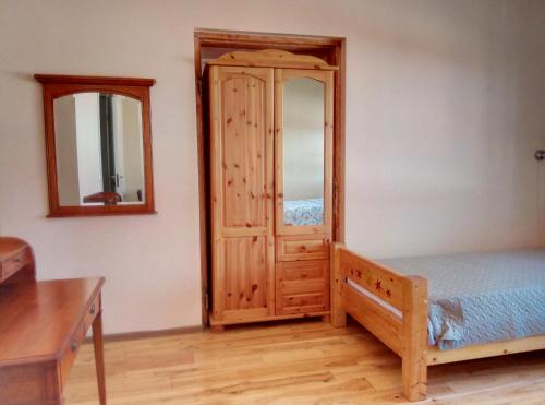 a bedroom with a wooden cabinet and a mirror at TäheMaja3 in Viljandi