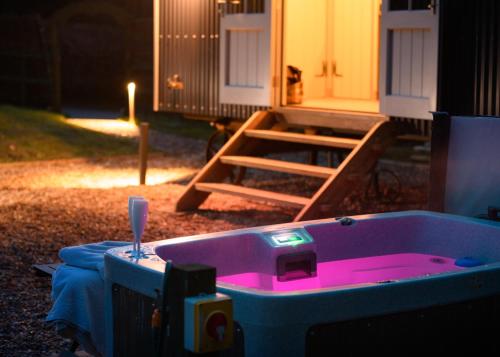 a jacuzzi tub in the yard of a house at Nutkins Luxury Shepherd Hut with hot tub close to Lyme Regis in Uplyme