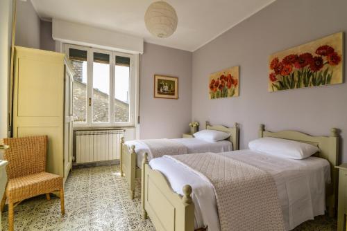 a bedroom with two beds and a window at Villa Ariola in Villafranca in Lunigiana