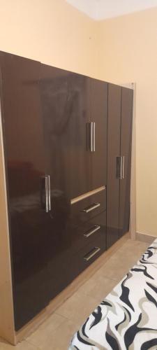 une grande armoire noire dans une chambre avec un lit dans l'établissement Departamentos Tilcara, à Tilcara