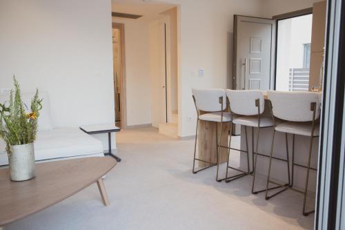 - un salon avec des chaises blanches et une table dans l'établissement Plataria Sunrise Resort, à Plataria