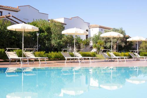 聖瑪麗亞納瓦雷的住宿－Marina Torre Navarrese Resort，度假村内带椅子和遮阳伞的游泳池