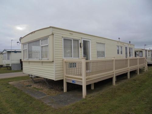 a mobile home with a porch and a deck at 6 Berth on Golden Anchor (Cascade) in Chapel Saint Leonards