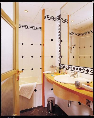 une salle de bain avec un lavabo, une baignoire et un miroir dans l'établissement Hotel Restaurant 