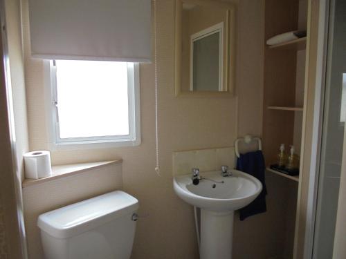 a small bathroom with a toilet and a sink at 6 Berth on Golden Anchor (Cascade) in Chapel Saint Leonards