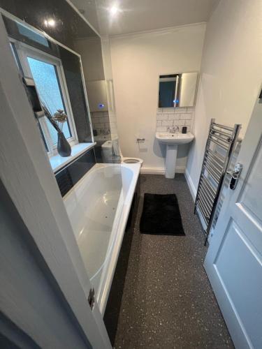 baño con bañera grande y lavamanos en Weardale House, en Billingham