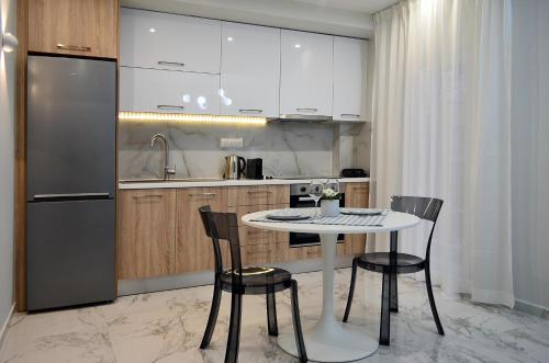 een keuken met een tafel en stoelen en een koelkast bij Ippokratio Luxury Studio in Thessaloniki