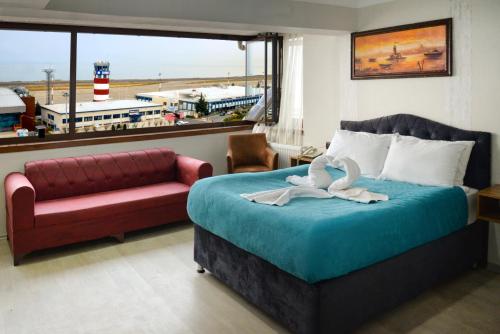 a bedroom with a bed and a couch and a window at Elite Holiday Hotel in Trabzon