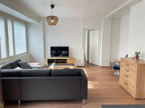 a living room with a couch and a tv at Cozy & modern central-apartment in Turku