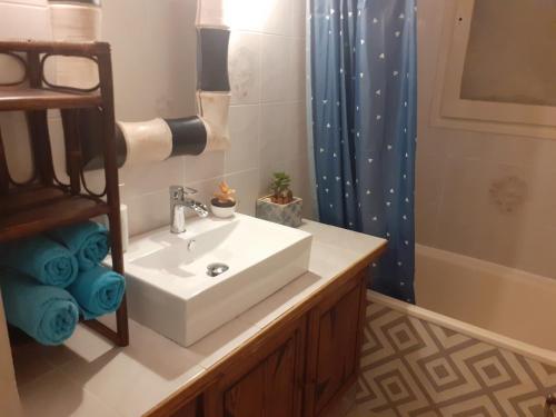 La salle de bains est pourvue d'un lavabo blanc et d'une douche. dans l'établissement Villa 3 étoiles près des plages, Parking, Wifi, Clim, à Sauvian