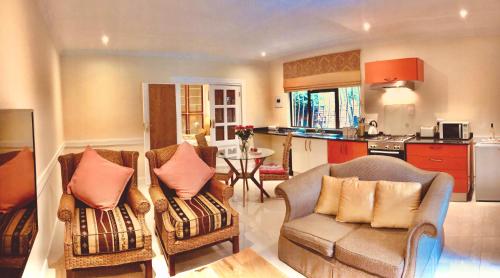 sala de estar con 2 sillas y cocina en 27A on Angus, en Johannesburgo