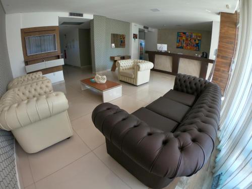 a living room with a couch and two chairs at Tambau Beach Hotel in João Pessoa