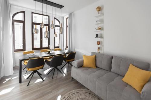 a living room with a couch and a table at Bheaven I Golden Wave Premium Apartment in Bremerhaven