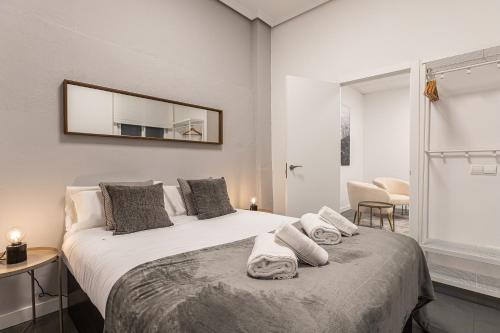 a bedroom with a bed with towels on it at BNBHolder Cheerful La Latina in Madrid