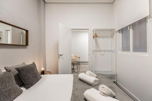 a bedroom with a white bed with towels on it at BNBHolder Cheerful La Latina in Madrid