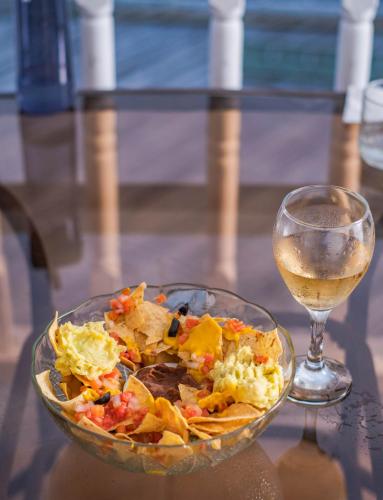a bowl of salad next to a glass of wine at Harbour View Boutique Hotel & Wellness Retreat in Belize City
