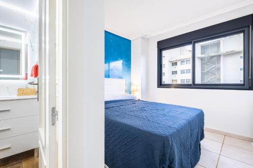 ein Schlafzimmer mit einem blauen Bett und einem Fenster in der Unterkunft Tamarindo Apartment 7-F Playa La Cala Beach in Villajoyosa