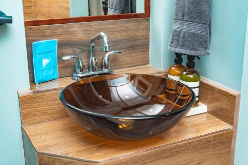 a sink in a bathroom with a wooden counter at Harbour View Boutique Hotel & Yoga Retreat in Belize City