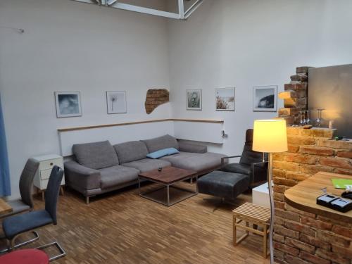 a living room with a couch and chairs and a table at Loft Wellness City Center in Leipzig