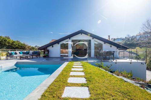 a home with a swimming pool and a house at PROMO Easy Clés - 5 bedrooms villa heated pool AC in Saint-Jean-de-Luz